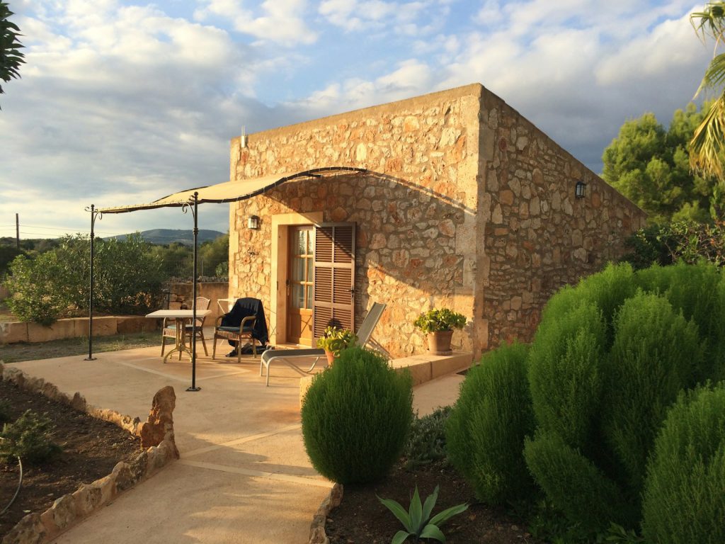 a stone building with a patio and umbrella Mallorca