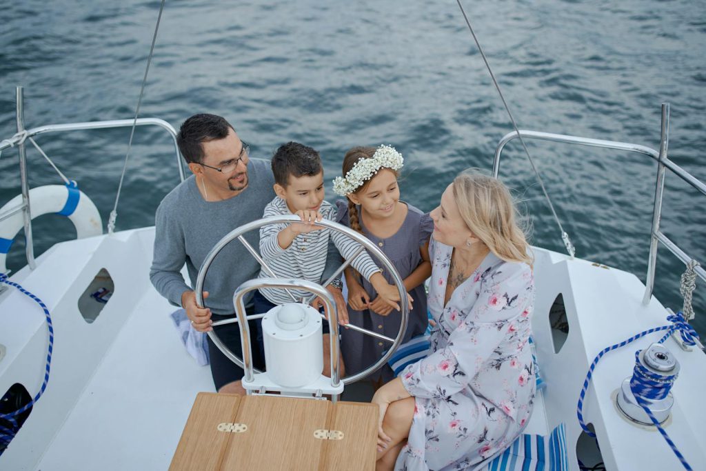 Happy family on yacht sailing on sea during trip vaarvakantie kinderen gezin