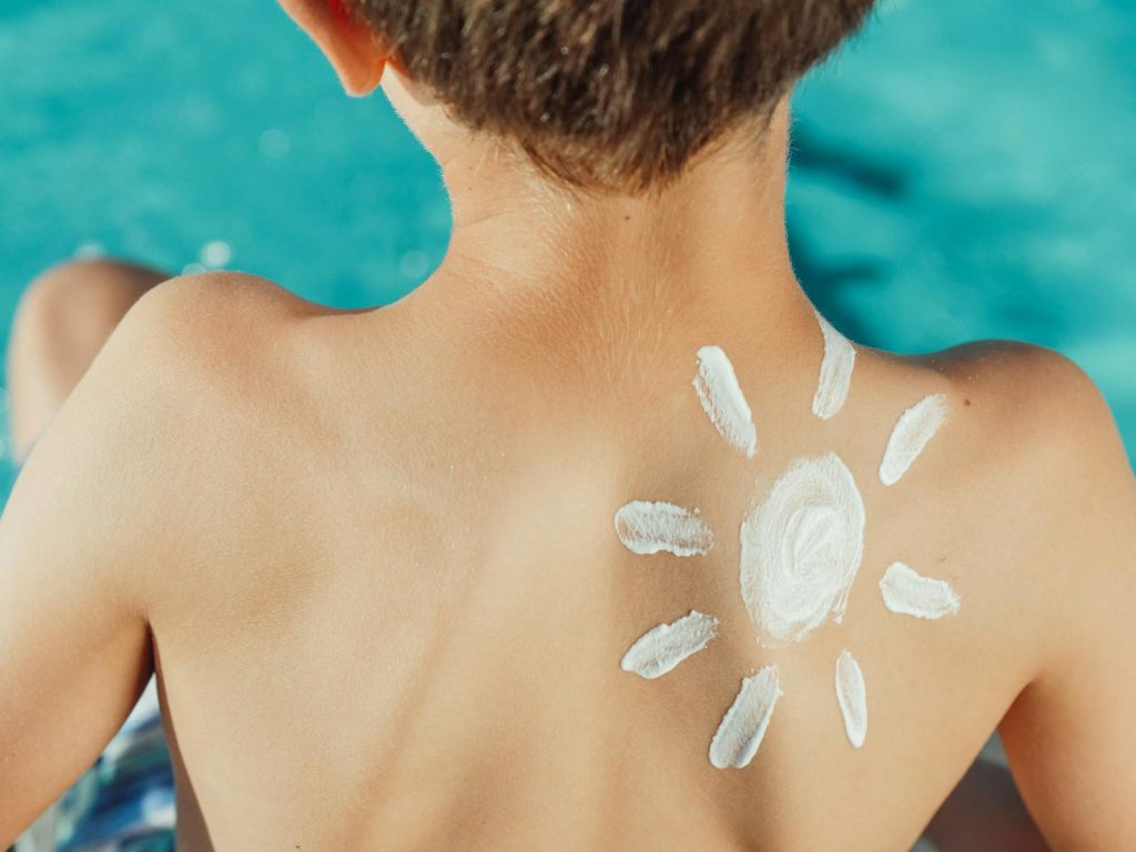 Sun Drawing Sunscreen on Child s Back Photo kamperen met kinderen zonnebrand kind zonnetje 