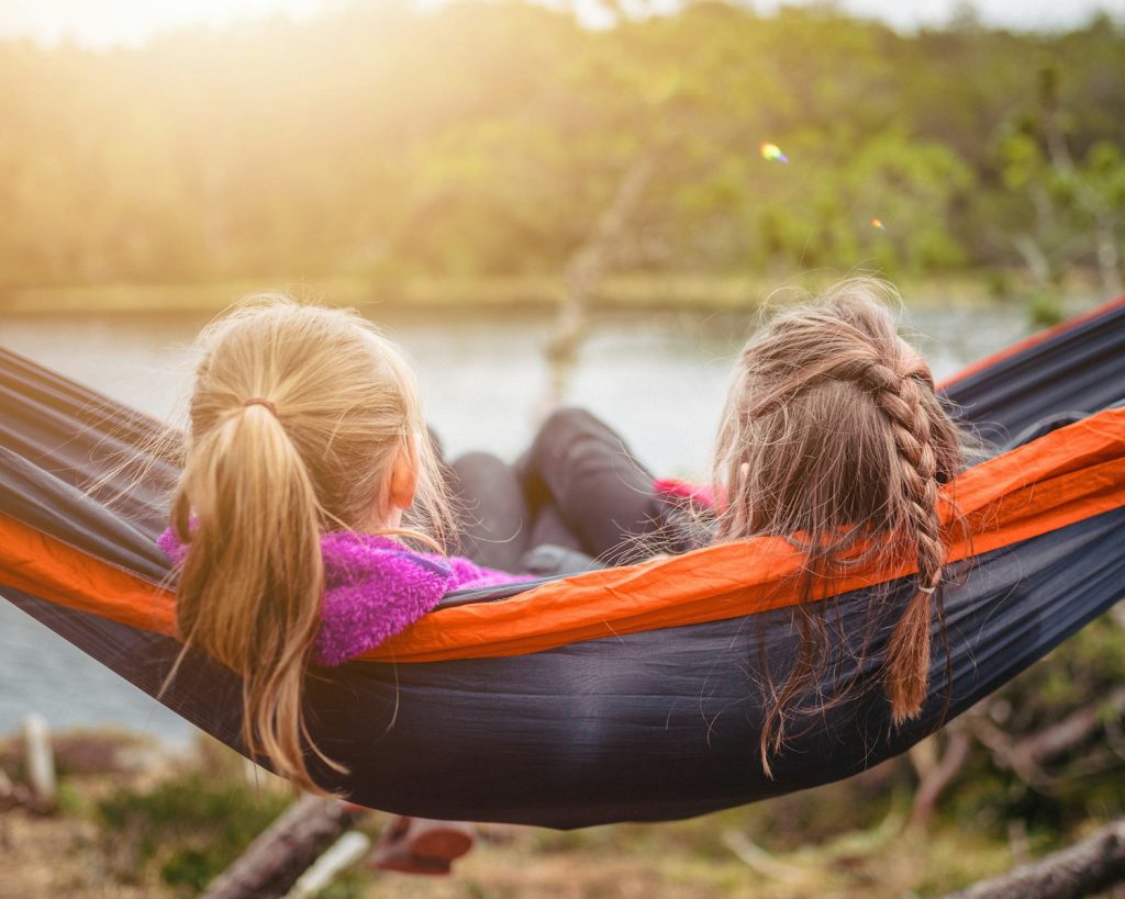 two women lying on hammock kamperen met kinderen